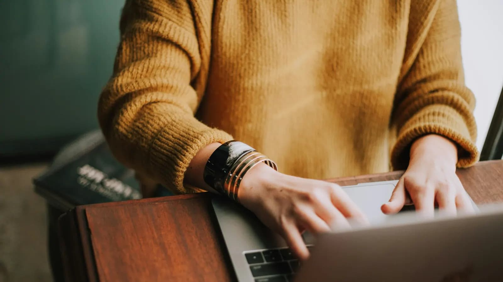 Empreendedora trabalhando no notebook em uma mesa de madeira
