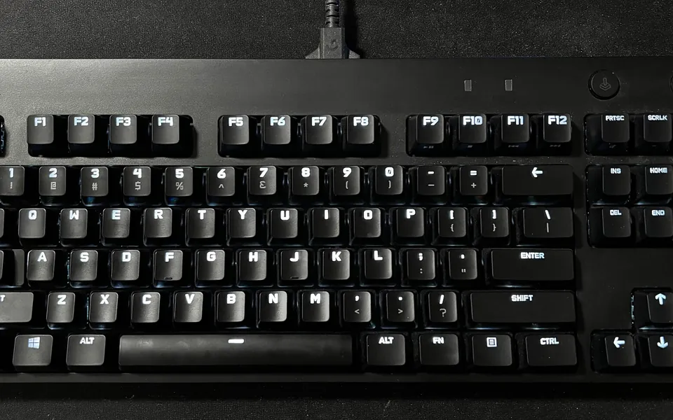 Teclado gamer preto com as teclas iluminadas em branco, visto de cima