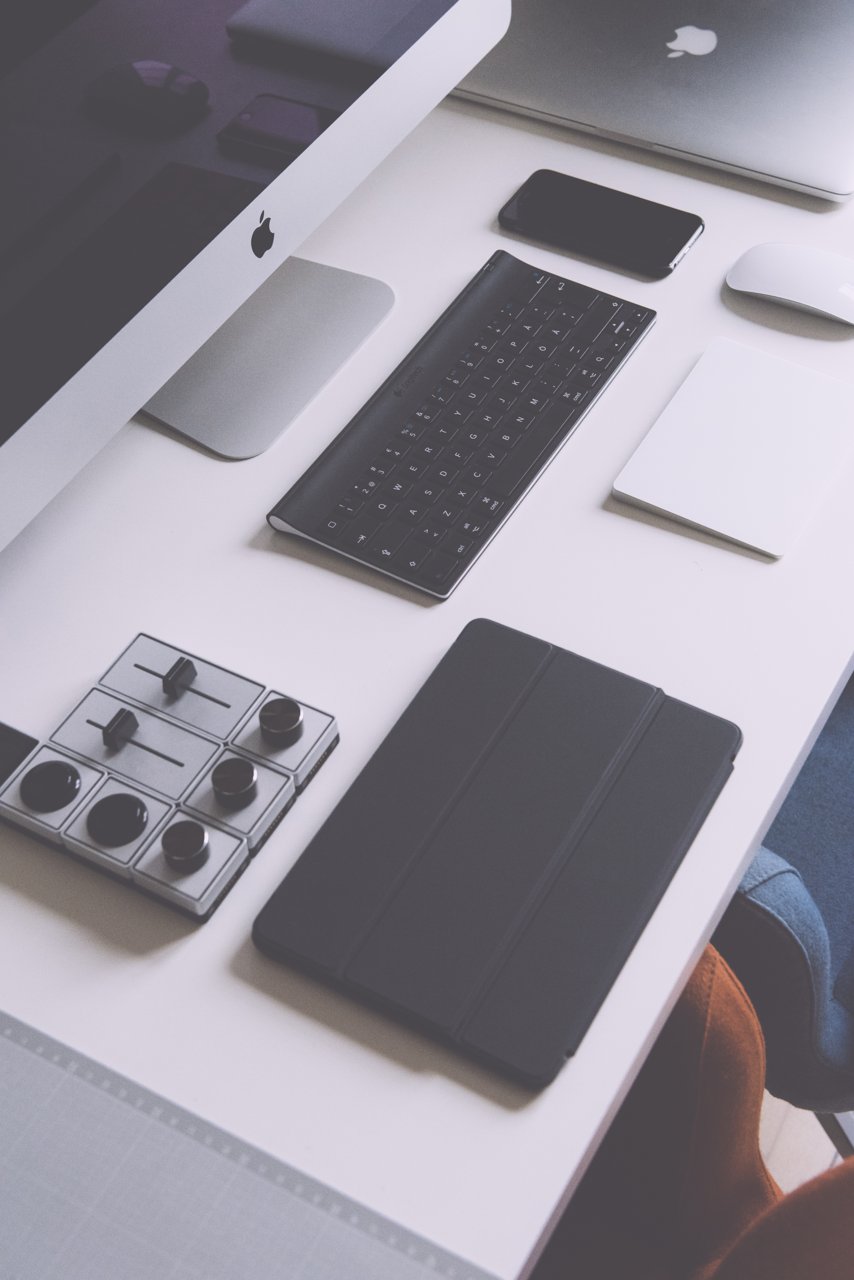 Celular e outros aparelhos sobre uma mesa de trabalho
